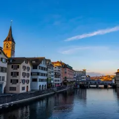 Widok na rzekę Limmat z charakterystyczną wieżą kościoła i zabytkowymi kamienicami. Tak właśnie wygląda Zurych, gdzie jest zurych.