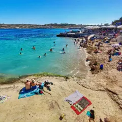 Malta w maju to idealna pogoda na plażowanie. Turkusowa woda, piaszczysta plaża i mnóstwo ludzi cieszących się słońcem.