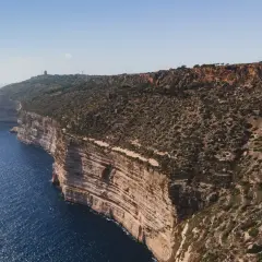 Malta: klify nad turkusowym morzem, skaliste wybrzeże z roślinnością.
