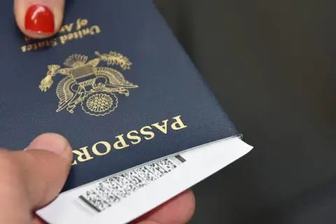 Dłoń trzyma paszport USA, gotowy do podróży do krajów poza Unią Europejską.