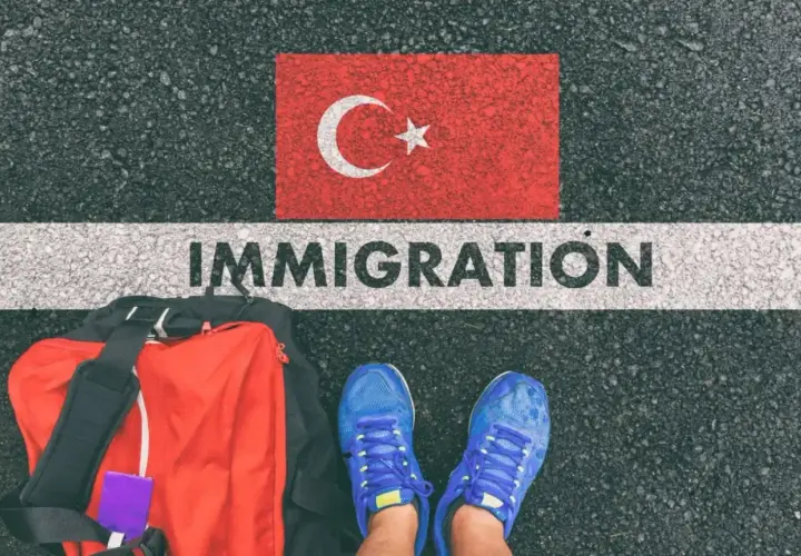 Bagaż i buty gotowe do podróży. Czy do Turcji potrzebny jest paszport? Słowo "IMMIGRATION" na drodze pod flagą Turcji.