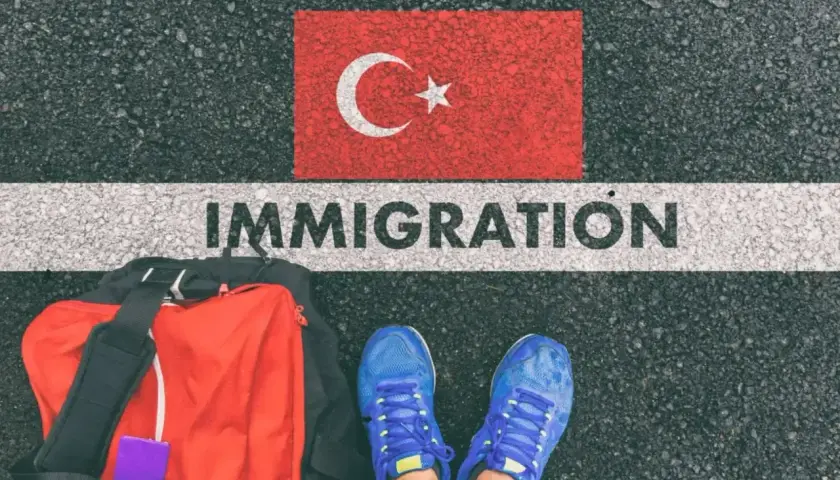 Bagaż i buty gotowe do podróży. Czy do Turcji potrzebny jest paszport? Słowo "IMMIGRATION" na drodze pod flagą Turcji.