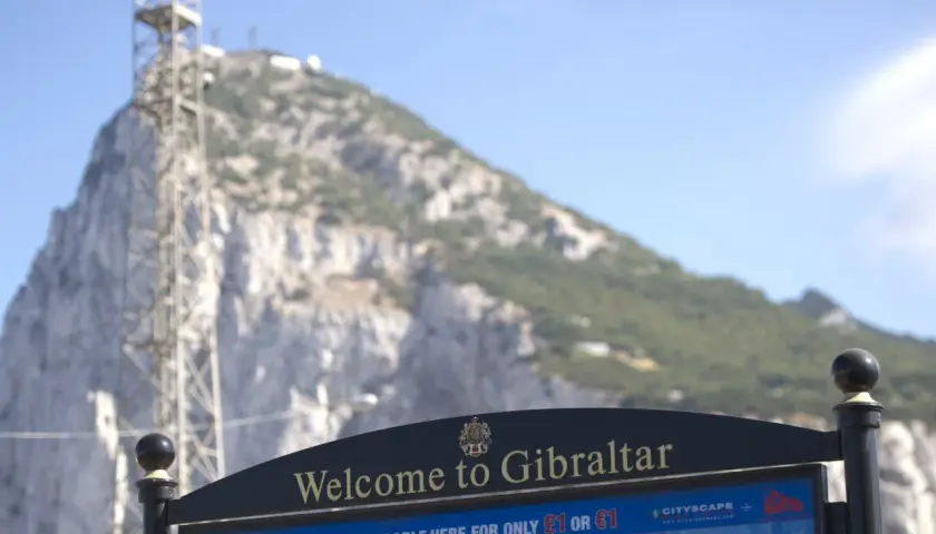 Tablica "Welcome to Gibraltar" przed skalistym zboczem. Czy Gibraltar to państwo? Mapa i przewodnik dostępne za 1 funta lub 1 euro.