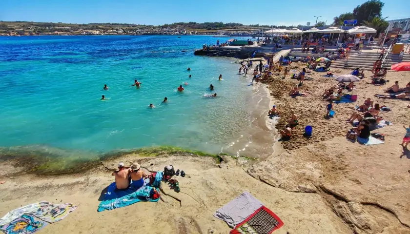 Malta w maju to idealna pogoda na plażowanie. Turkusowa woda, piaszczysta plaża i mnóstwo ludzi cieszących się słońcem.