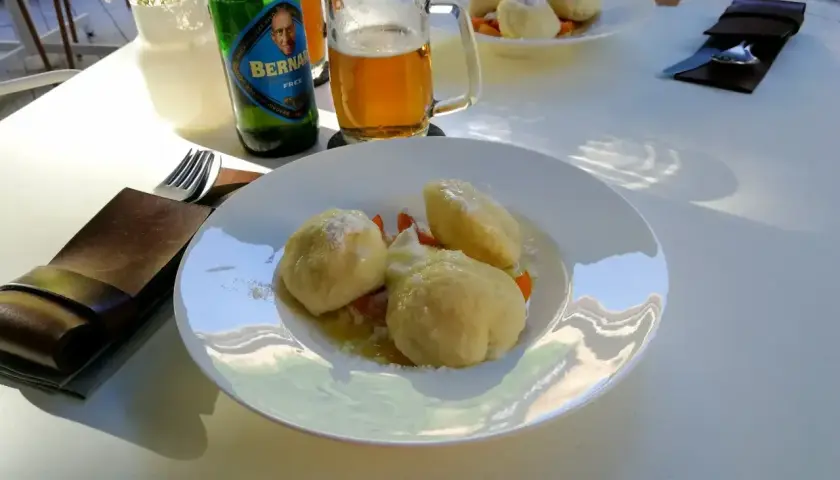 Ołomuniec gdzie zjeść? Pyszne knedliki z owocami i piwo Bernard na stole. Idealne miejsce na posiłek.