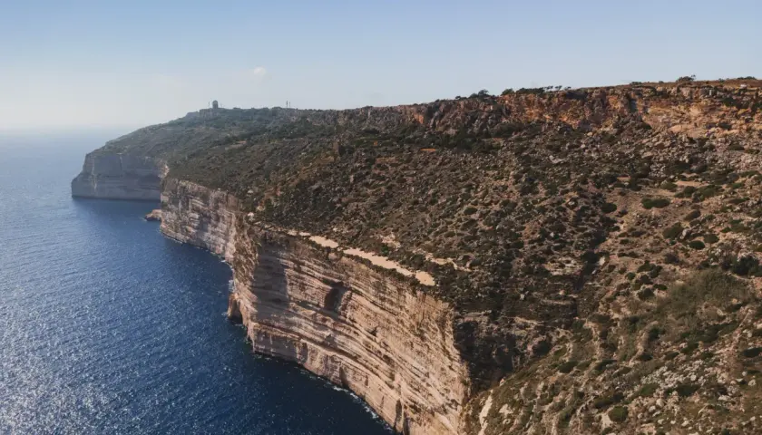 Malta: klify nad turkusowym morzem, skaliste wybrzeże z roślinnością.