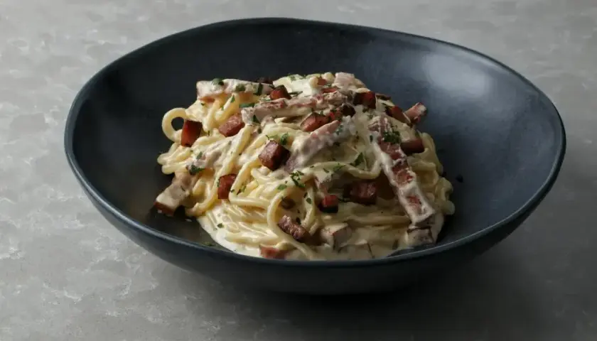 Pyszna carbonara w czarnej misce, idealna inspiracja, jak zrobić carbonare.