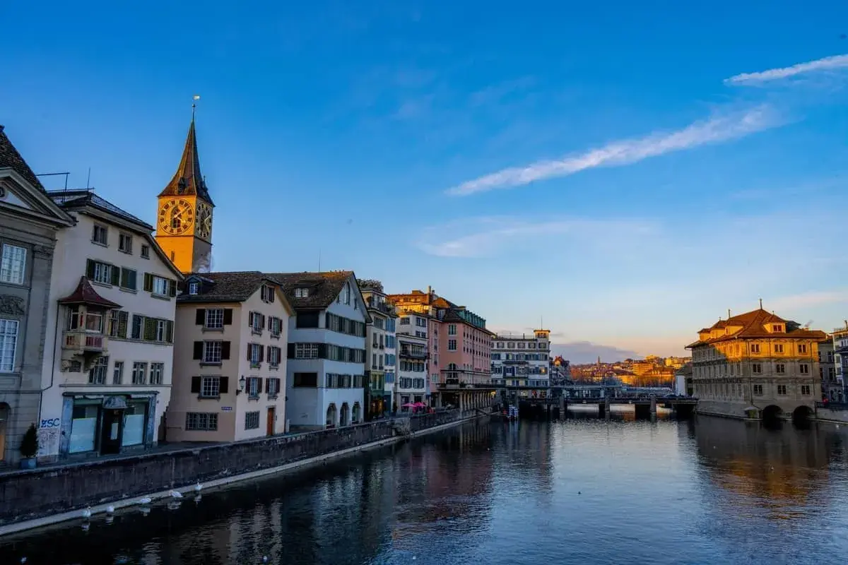 Widok na rzekę Limmat z charakterystyczną wieżą kościoła i zabytkowymi kamienicami. Tak właśnie wygląda Zurych, gdzie jest zurych.