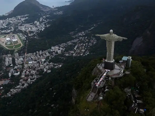 Widok na Rio de Janeiro z pomnikiem Chrystusa Odkupiciela. Widać gęstą zabudowę miasta i zalesione wzgórza, świadczące o dużej brazylijskiej ludności.